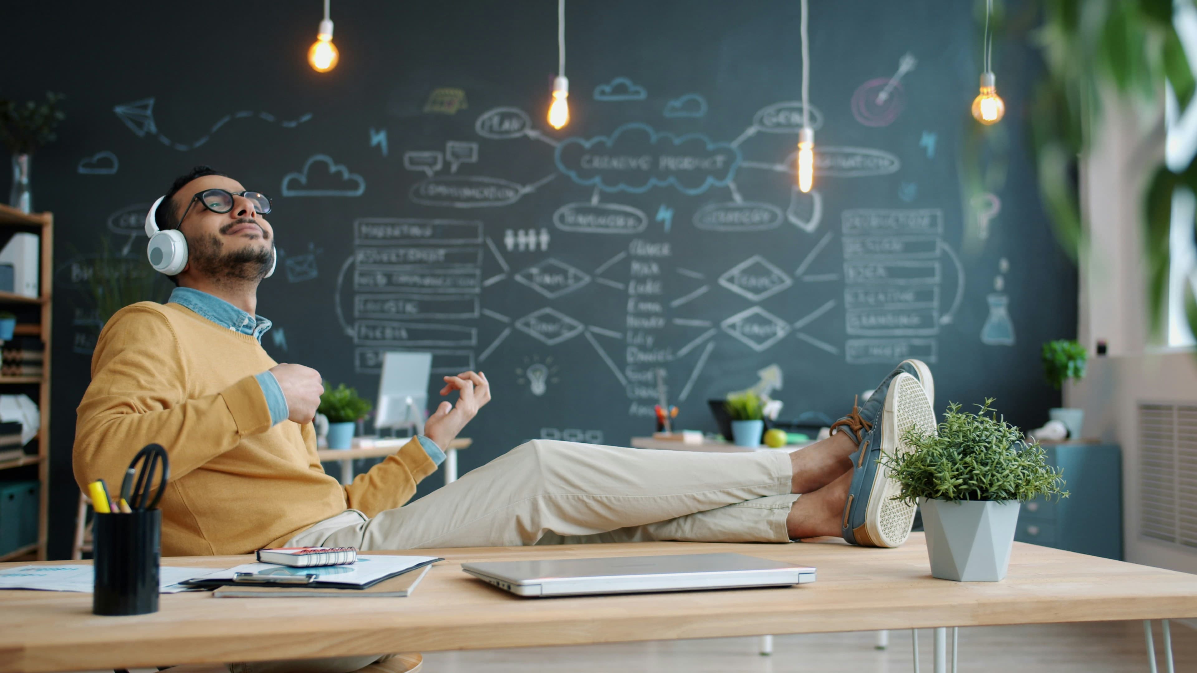 A business owner relaxing with his feet up while his AI agents handle the work